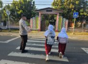 Polsek Sekongkang Intensifkan Rawan Pagi, Personel Bantu Pelajar Menyeberang Jalan
